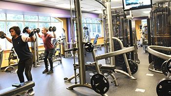 students exercising in a campus gym