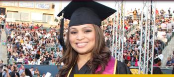 graduate in cap and gown smiling at commencement