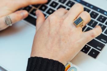 close-up of hands typing on a laptop