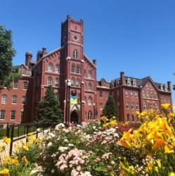 historic red brick building with flowers in foreground