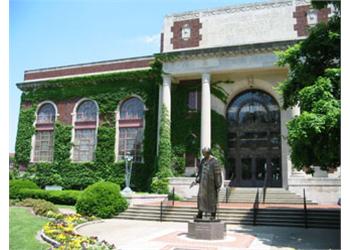 ivy-covered building with statue in front of the entrance