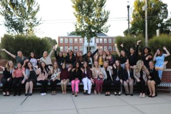 large group of students posing with raised arms