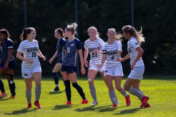 women's soccer team playing a match on the field