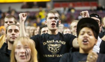 crowd at a basketball game with 'oakland basketball' shirts