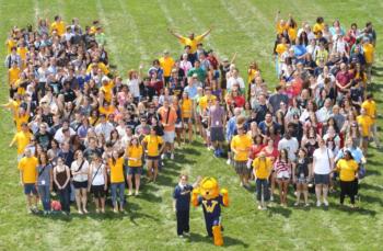 crowd forming a 'V' with mascot in foreground