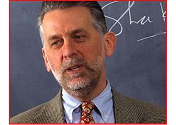man with beard in front of blackboard