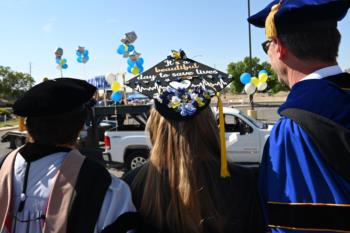 graduates wearing caps with text: 'it’s a beautiful day to save lives'
