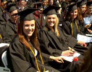 graduates in black robes sitting during commencement