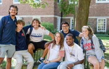 students sitting and smiling on a bench outdoors