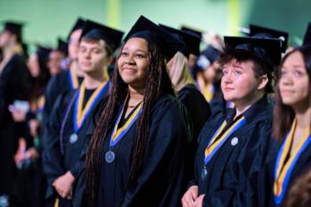 graduates in caps and gowns with medals and tassels