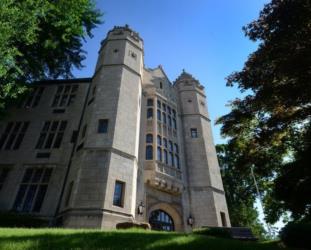 historic stone building with towers and arched windows under a blue sky