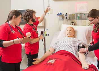 nursing students practicing on a mannequin