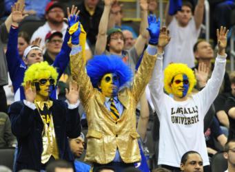fans in blue &amp; gold wigs at a sporting event