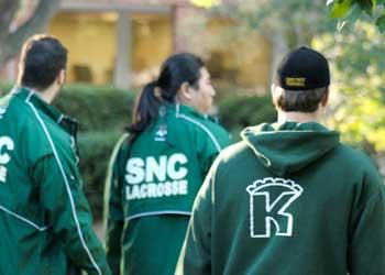 students wearing 'snc lacrosse' jackets walking