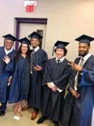 graduates in caps and gowns posing together