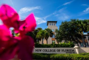 pink flower foreground with 'new college of florida' sign