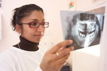 woman examining a dental x-ray